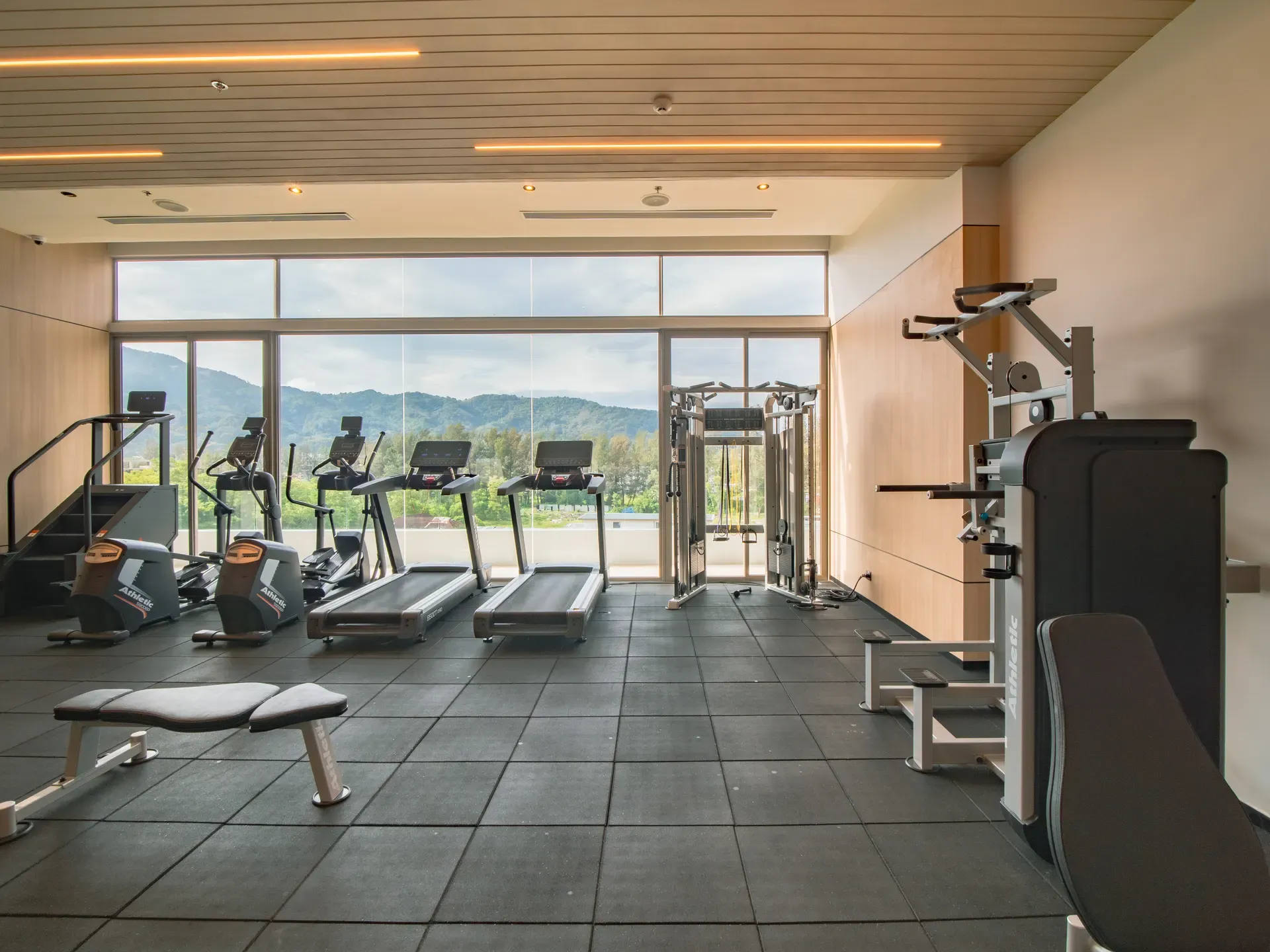 The modern air-conditioned hotel gym at Sole Mio with cardio machines and a mountain view