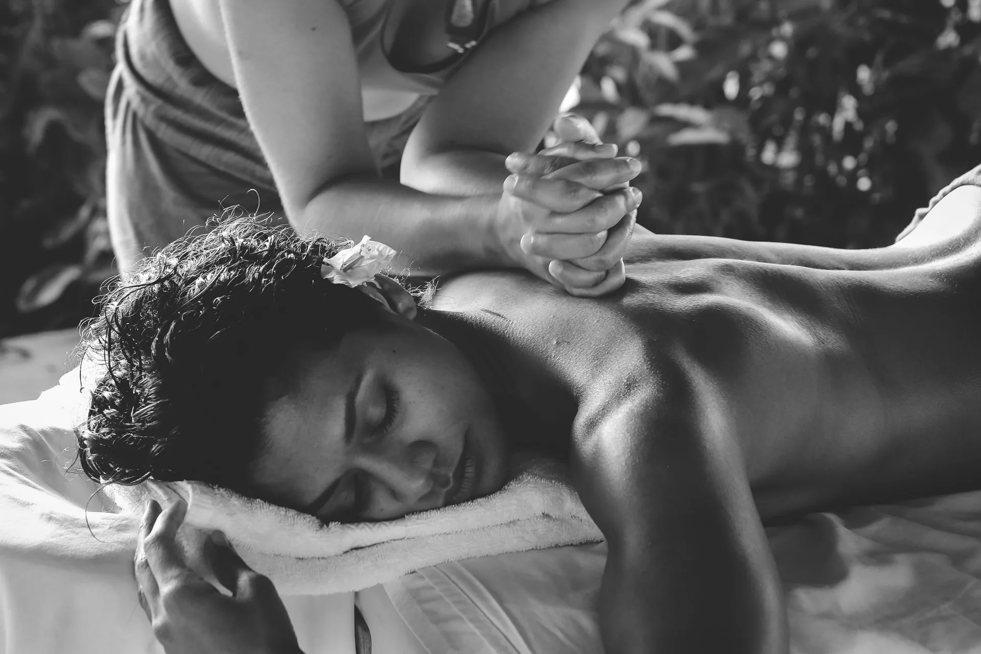 Thai massage treatment for a wellness retreat in Thailand, shown in a calm black-and-white spa setting