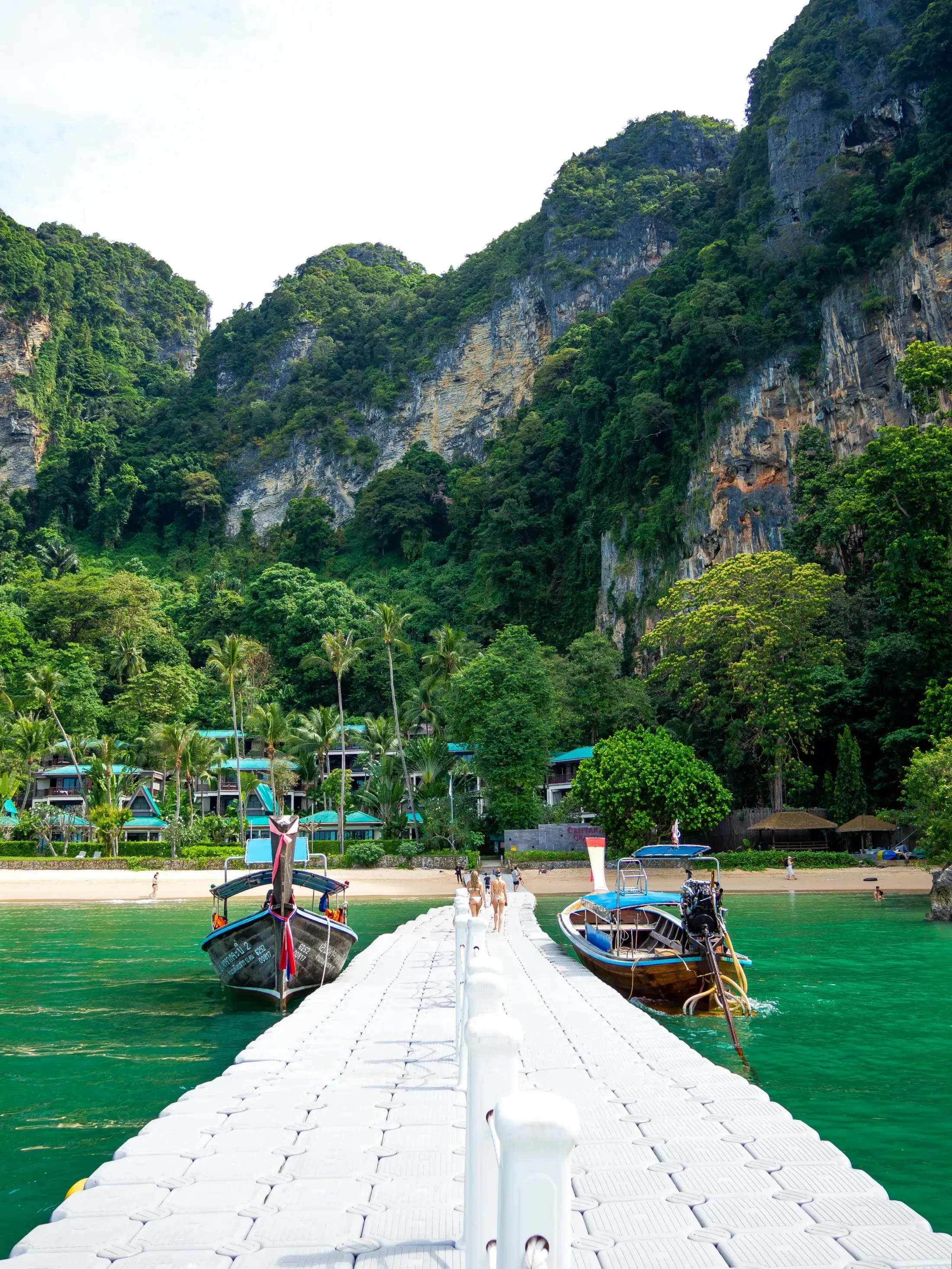 Railay pier with longtail boats and limestone cliffs in Thailand